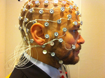 a photo of a man wearing an EEG cap covering his scalp and face