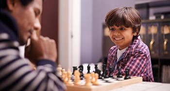 a photo of a man and a boy playing chess