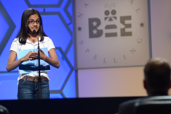 a girl competing in a spelling bee standing on stage
