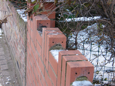 a wall with three bricks that look like they have faces