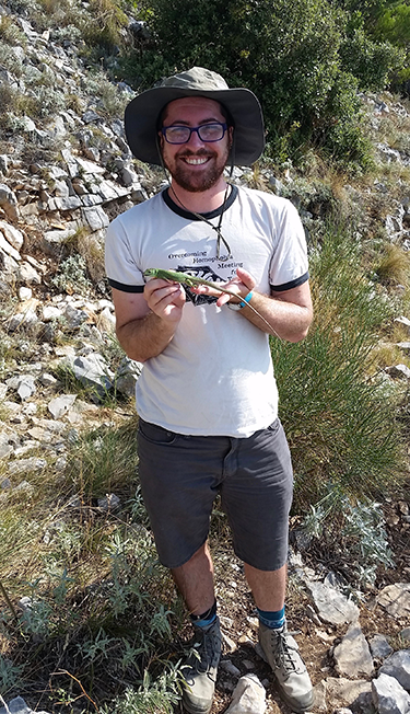 a photo of Wehrle holding a lizard out in the field