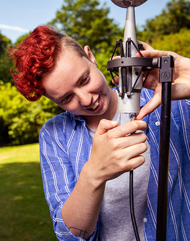 a photo of Kat Young adjusting a microphone