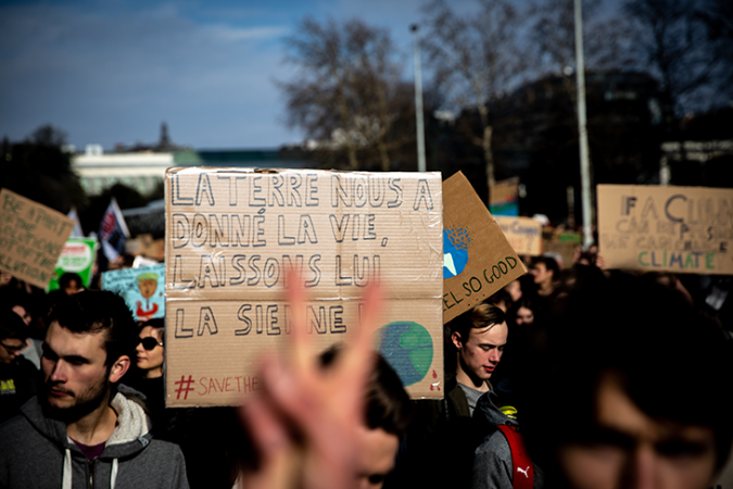 a photo of students carrying signs in English and French at a climate protest in Brussels