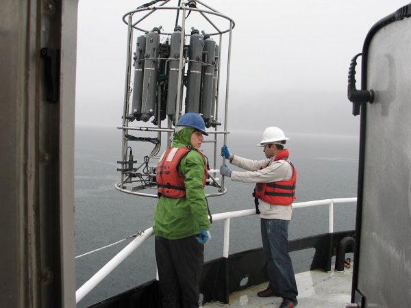 Scientists on a research ship prepare to lower an instrument, called a CTD rosette, into the ocean. The rosette, lowered on a cable, can sample water at different depths in the ocean, starting near the surface and going down thousands of feet. Water sampled this way allows scientists to discover microbes that grow deep down in the ocean. Credit: David Stahl (University of Washington)