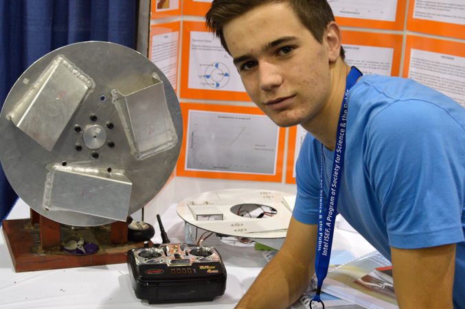 Phillipe Lothaller, a 17-year-old senior from Cape Town, South Africa, has invented a device that could save airlines big money by extending the life of tires. The metal device at left is an early mock-up of the design. A newer version (seen in white at center) has pop-up scoops instead of fixed ones. When retracted, the scoops don’t interfere with a plane’s protective wheel wells. Credit: Patrick Thornton, SSP