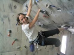 Emily climbs a wall at the gym.