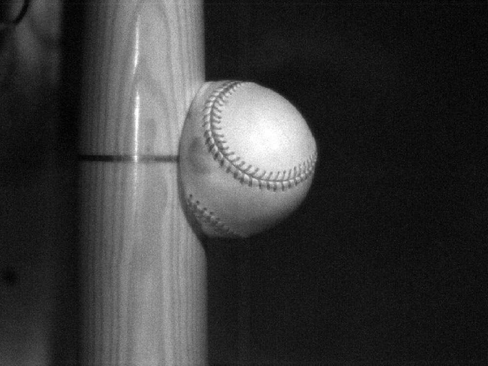 a photo of a ball slamming into a baseball bat