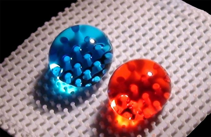 Researchers can create surfaces that repel droplets of water-based solutions (dyed blue) as well as those that are oil-based (a chemical called hexadecane, dyed red). They do this by adding a coat of super-repellent chemicals to tiny structures that act like a bed of nails. Credit: A. Tuteja and W. Choi