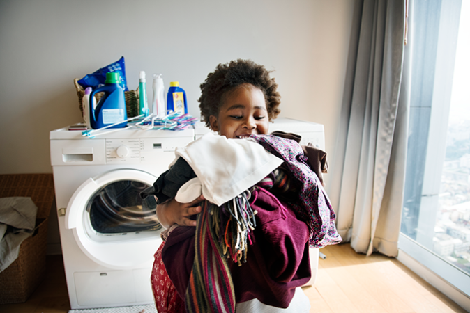 a kid carrying a load of laundry