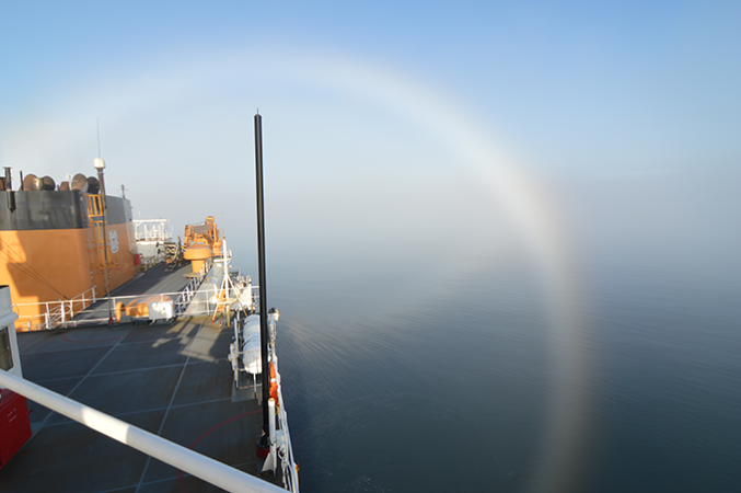 a fogbow from atop an icebreaker arcing below the horizon