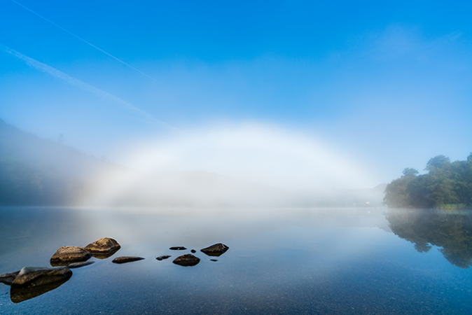 a fogbow over a lake