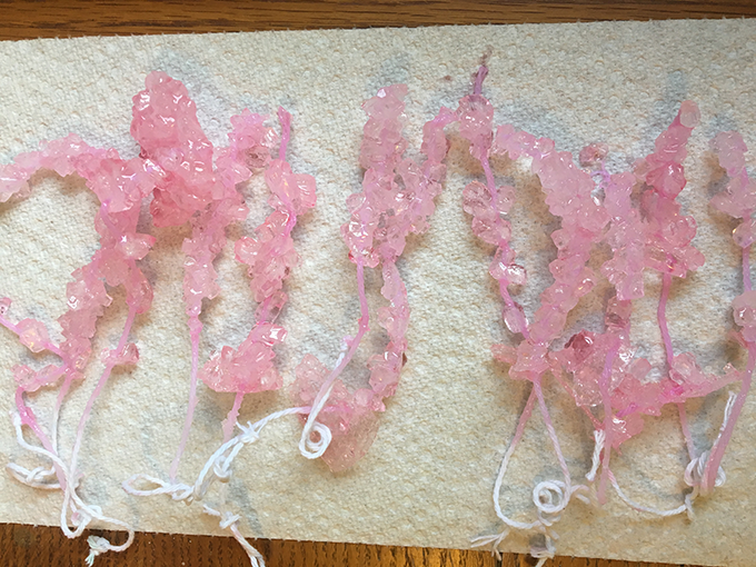 a row of light pink rock candy on strings