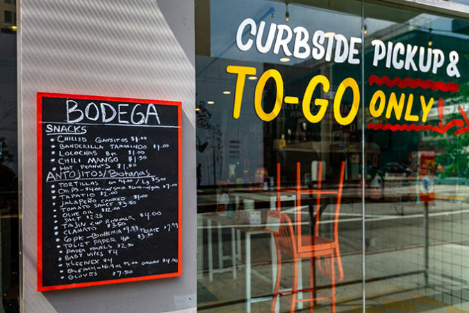 a photo of a restaurant closed for business during the COVD-19 pandemic, with a menu of things available for curbside pickup