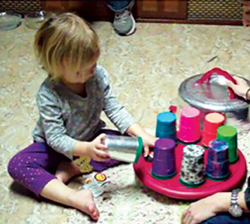 a photo of a child doing a spin-the-pots task