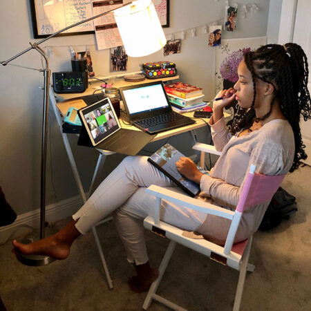 a photo of Nia Terry attending virtual class at her desk