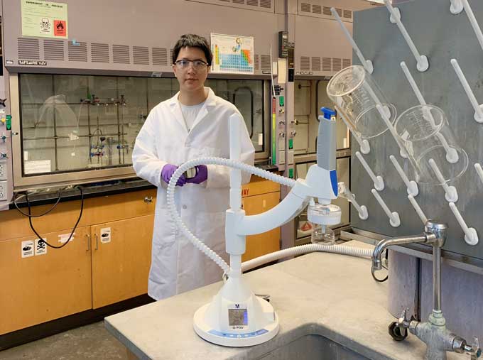 an asian man standing in a lab