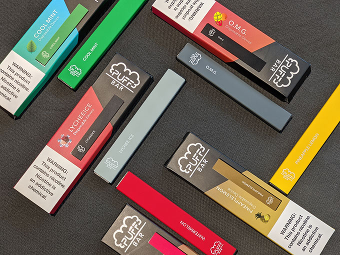 a photo of assorted Puff Bars (an e-cigarette) on a black background