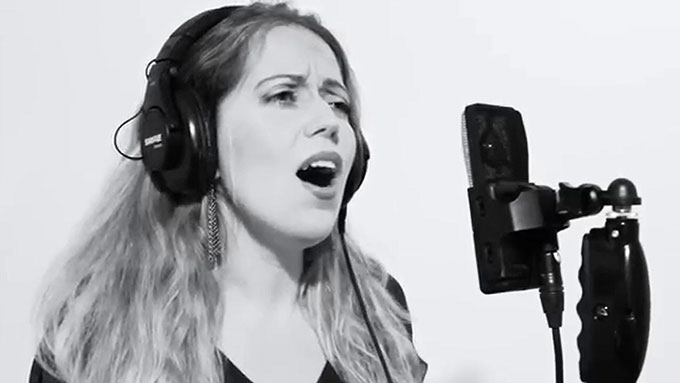 a black and white photo of Maya Ackerman singing into a microphone