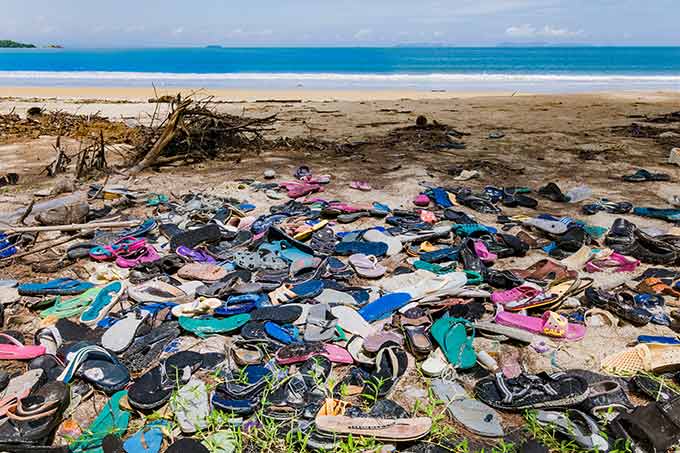a photo of piles of flip flops at a beach
