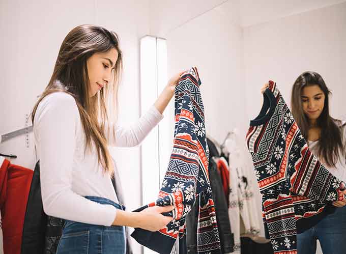 a woman considering buying a sweater in a store