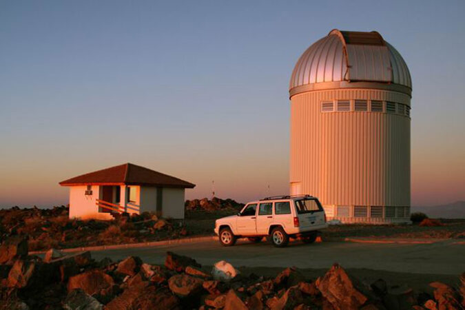 a phot of the OGLE telescope against an orange sky