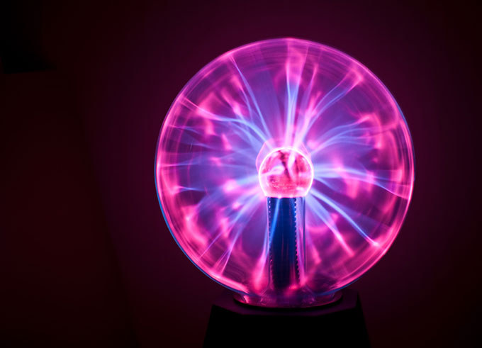 a photo of a plasma ball lit up with blue and purple plasma