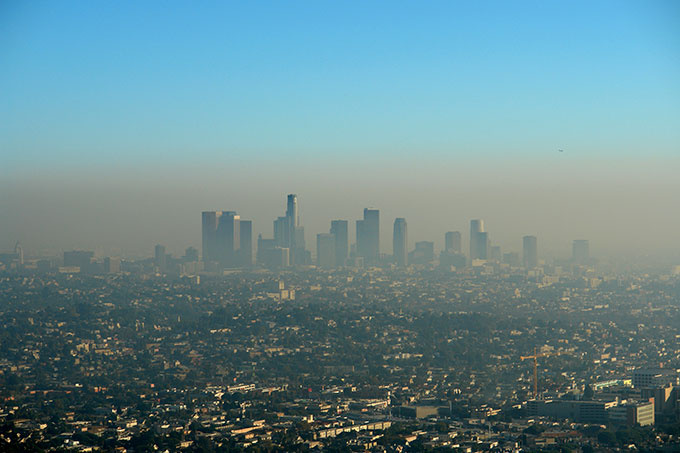 a photo of downtown LA from a distance, brown smog sits over the city