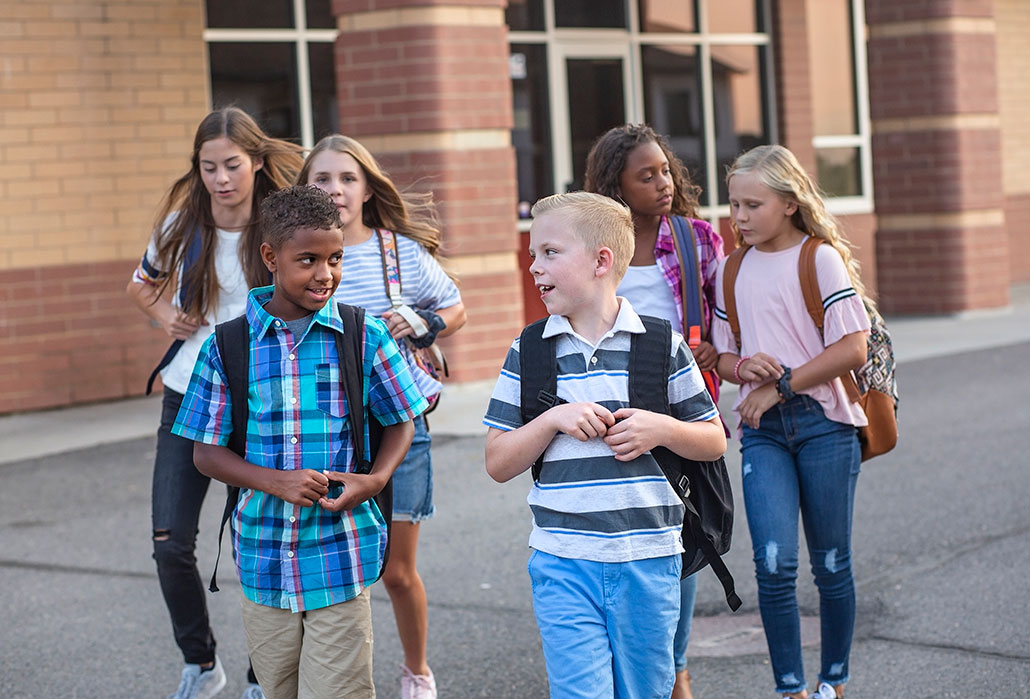 a group of diverse kids outside a school