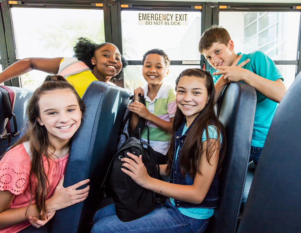 a group of diverse middle school kids on a bus