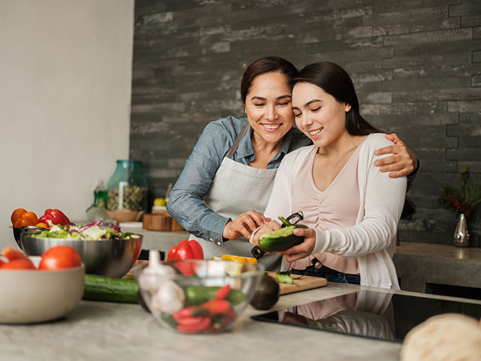 a mother and daughter prepping dinner together