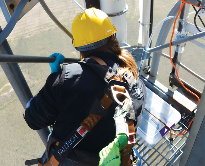 Joanne Emerson stands atop a tower with her back to the camera