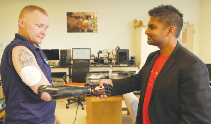 Garrett Anderson shakes hands with researcher Aadeel Akhtar