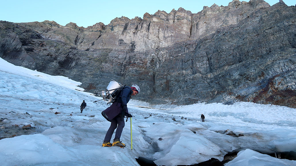 a photo showing a large rock shelf with the Dana glacier sitting underneath. Ellery is in the foreground.