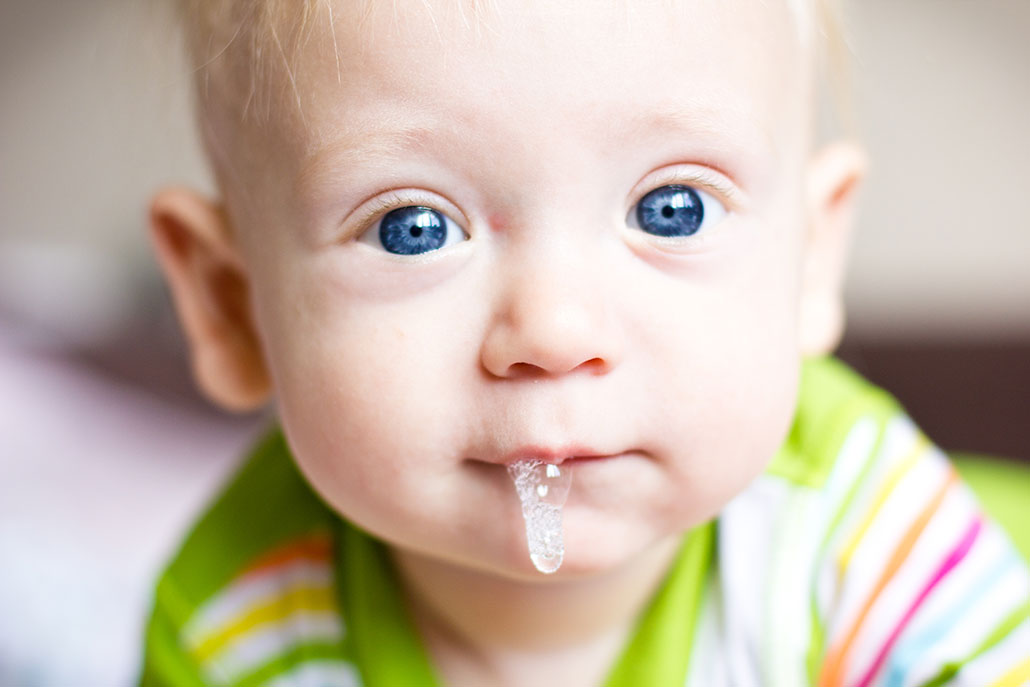 a photo of a pale baby with blue eyes and a lot of drool