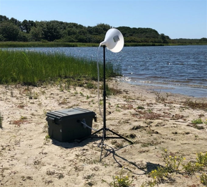 a photo of an air sampler on the shore of a pond