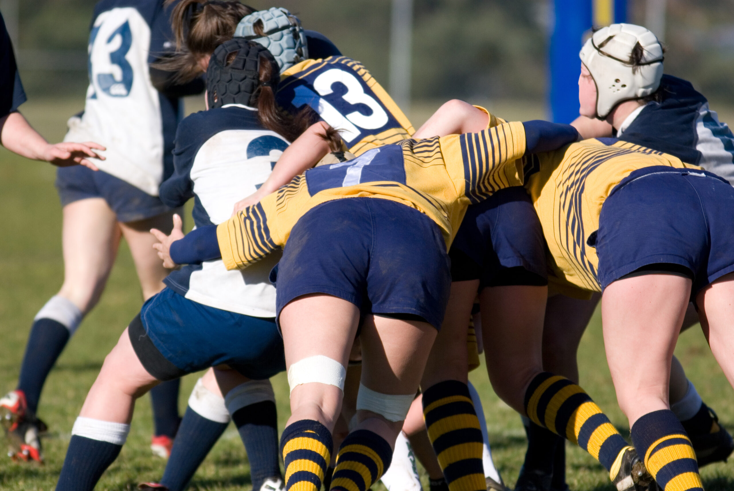 a group of girl rugby players mid-action on the field