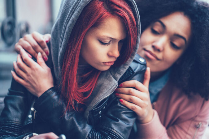 a girl hugging another girl