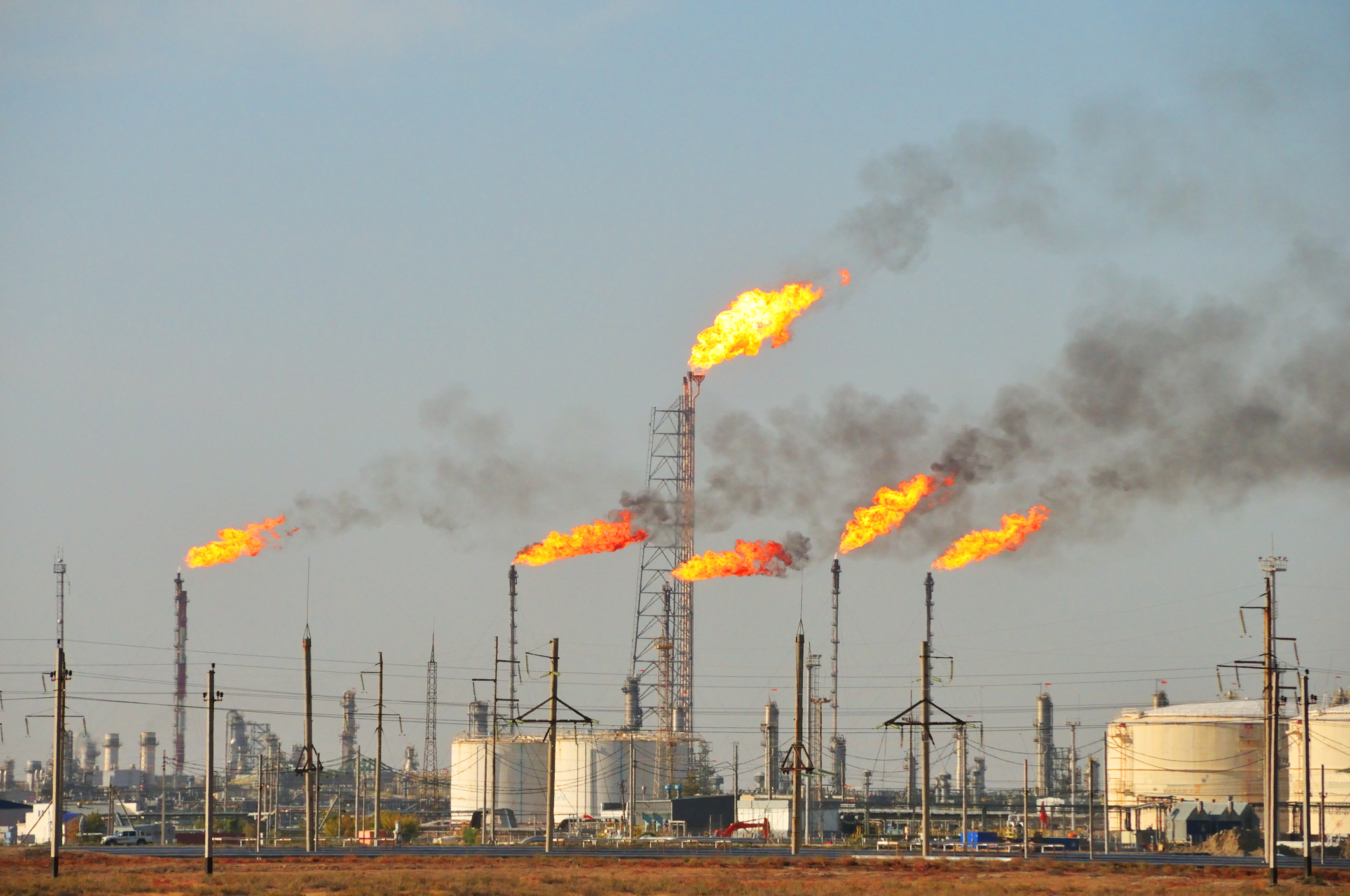 Flames rise from stacks at an oil refinery