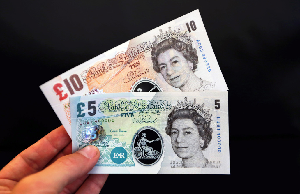 a photo of a hand holding a £10 banknote and a £5 banknote