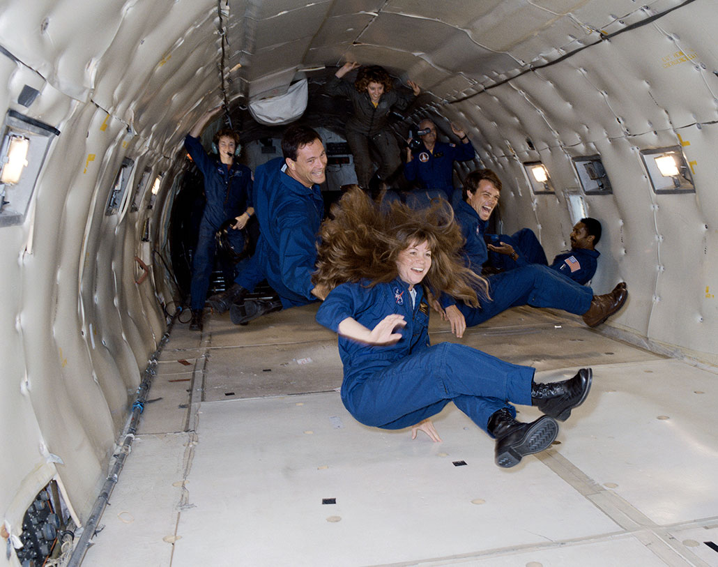 Astronauts inside a KC-135 jet float briefly in mid-air
