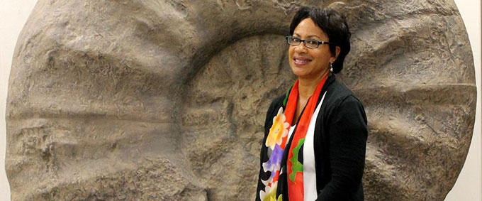 Lisa White in front of an enormous ammonite